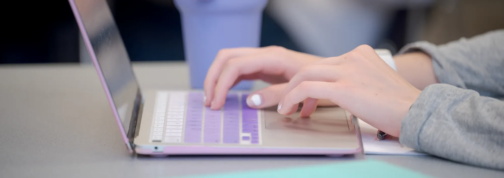 Close up of a student's hands working on a laptop computer